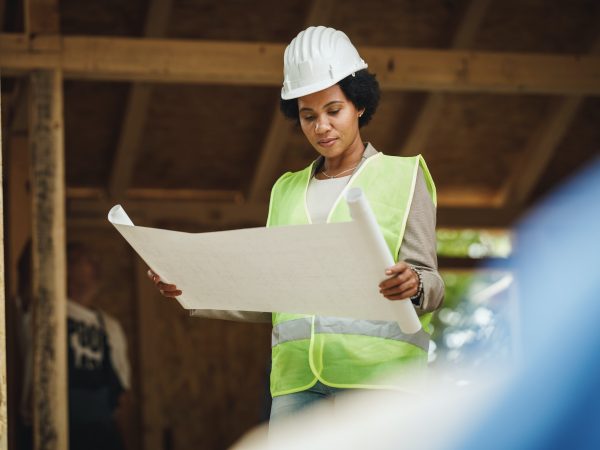 Construction Worker on Site with Plans